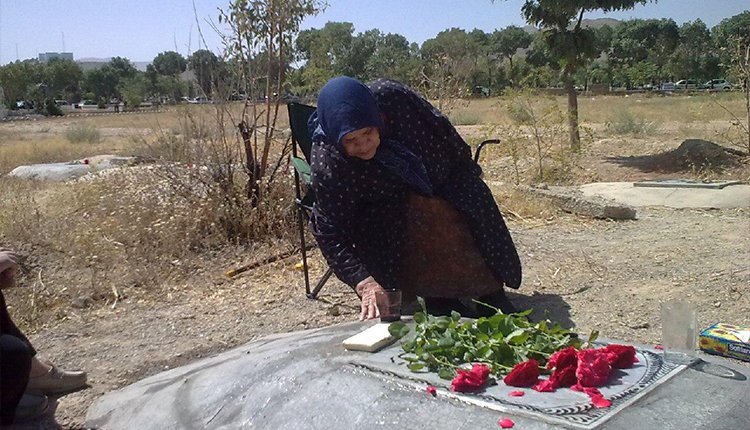 Die Mutter eines Opfers des Verschwindenlassens im Iran sitzt neben einem nicht markierten Grab Die Mutter eines Opfers des Verschwindenlassens im Iran sitzt neben einem nicht markierten Grab